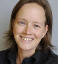 A smiling woman wearing a dark shirt